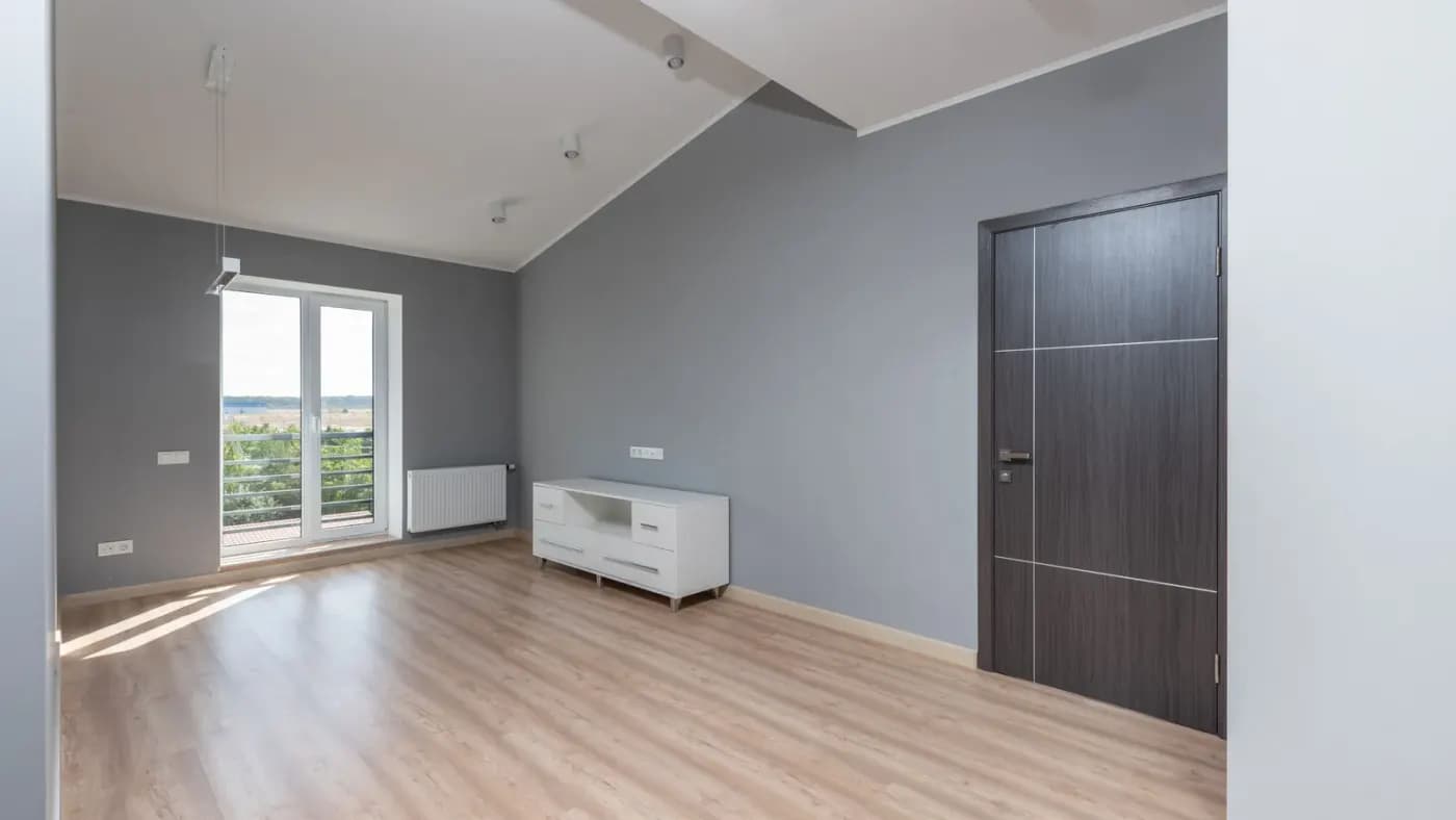 Balkon kapısı ve laminat zemini olan, yeni teslim edilmiş boş daire