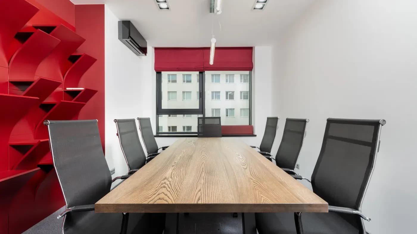 Uzun ahşap masası ve koltukları olan kurumsal toplantı odası
